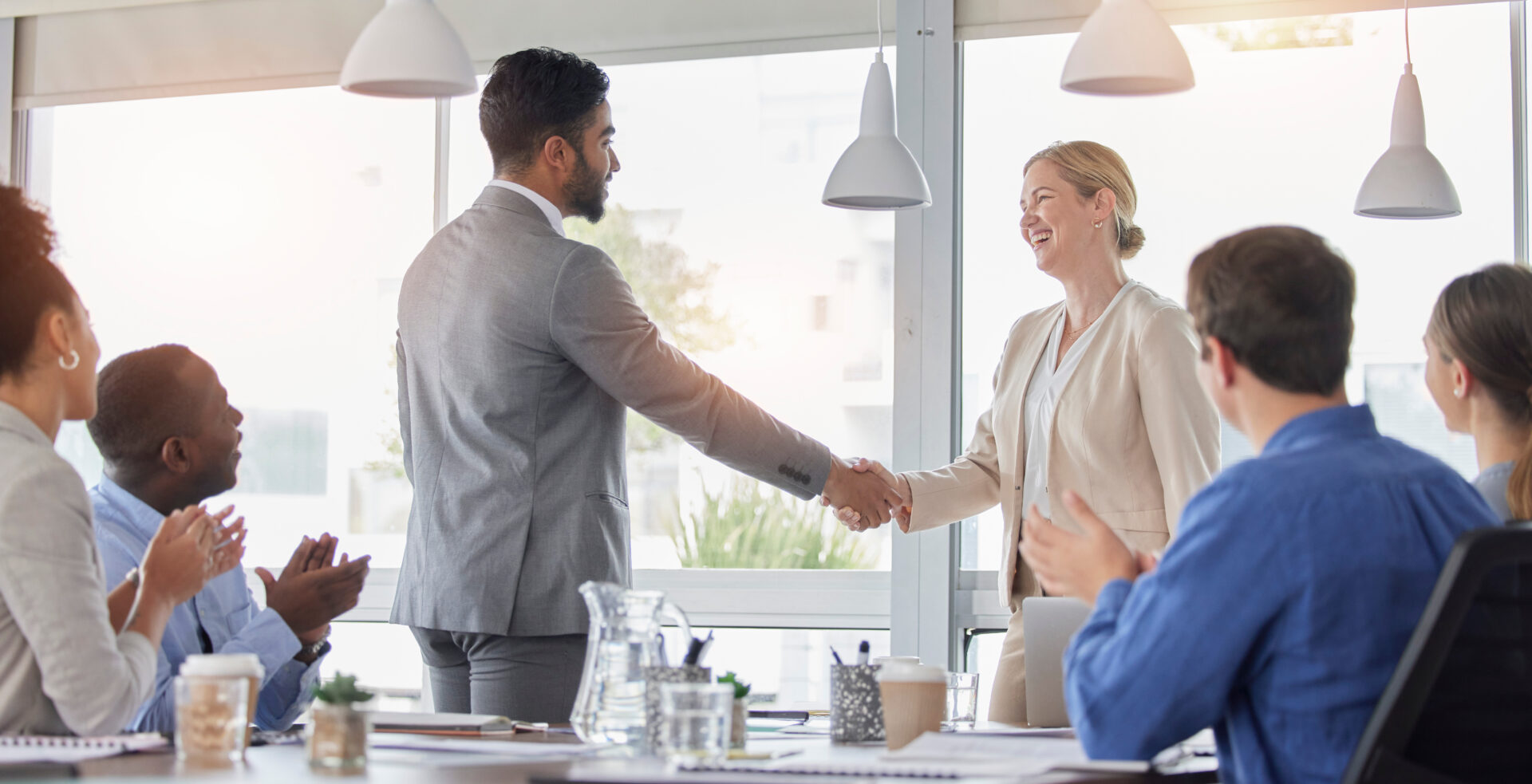 Handshake, applause and team of business people meeting for partnership, deal or agreement in office. Happy group clapping for collaboration, shaking hands and b2b integration, acquisition or success.